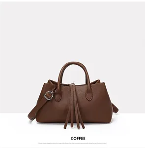 Detailed view of the coffee brown pebbled leather tote bag with elegant tassel accents