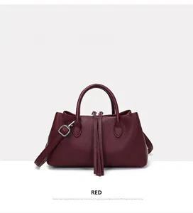 Side view of wine red pebbled leather tote bag with elegant tassel detail