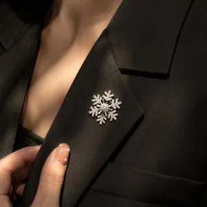 Detailed view of an elegant sparkling crystal snowflake brooch on a black suit lapel