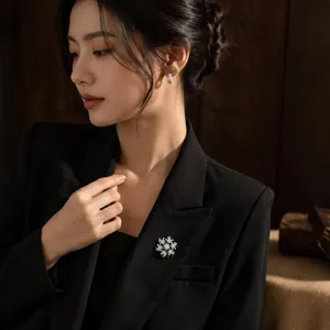 Elegant luxury silver snowflake brooch with sparkling crystals on a black blazer