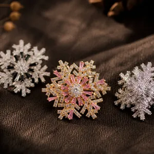 Close-up detail of luxury rotating snowflake brooches with pink and clear crystals.