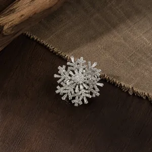 Close-up detail of a luxury rotating snowflake brooch with sparkling clear crystals for coats