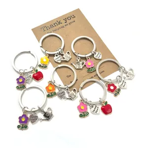 Détail de porte-clés colorés avec fleurs, pommes et breloques cœur sur une carte