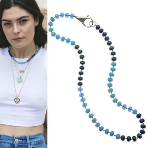 Detail van blauwe en groene abacus kralenketting op model en platte weergave voor zomerstyling