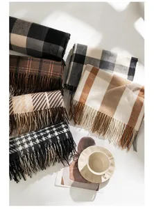 Collection of stylish plaid scarves with tassels in various autumn colors and textures.