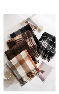 Macro view of various plaid scarves with tassels in autumn colors and soft textures