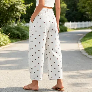 Detailed rear view of stylish white polka dot barrel jeans in a sunny park setting