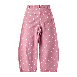 Back view of pink polka dot barrel leg denim pants showing twin rear pockets on white backdrop