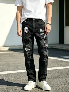Detailed view of men's distressed black denim jeans featuring embroidered street art patches