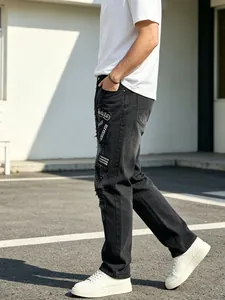 Close-up view of black distressed high street men's jeans with heavy embroidery patches