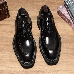 Top-down view of glossy black leather men's Oxford shoes with brogue details