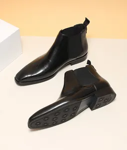 Vue détaillée de bottines Chelsea en cuir noir pour homme avec inscription gravée au laser.