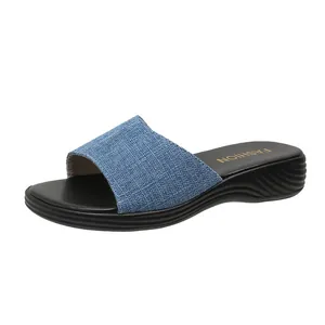 Detailansicht einer stilvollen blauen Denim-Keilsandalette für Damen mit schwarzer Sohle