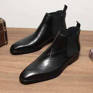 Vue détaillée de bottines Chelsea en cuir noir avec lettrage élégant gravé au laser