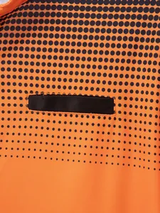 Close-up of black polka dot pattern on orange fabric of a men's Polo shirt