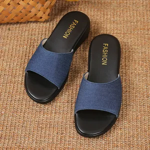 Draufsicht auf blaue Keilsandalen aus Denim mit schwarzem Fußbett und Golddruck