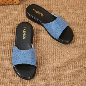 Draufsicht auf stilvolle blaue Denim Keilslippers für Damen auf einer Webmatte