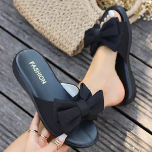 Detailansicht von eleganten schwarzen flachen Slippern mit einer großen Schleife