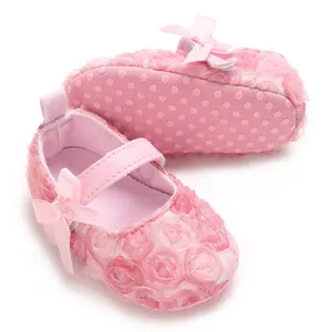 Close-up of pink baby Mary Jane shoes with 3D lace flowers and silk ribbon bow