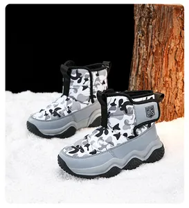 Close-up view of children's grey camouflage snow boots on a snowy background