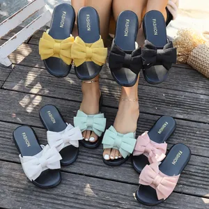Außendisplay bunter flacher Damen-Sandalen mit Schleife auf Holzdeck