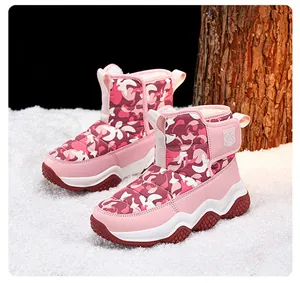 Detail view of pink camouflage children's snow boots with wavy midsole on snow