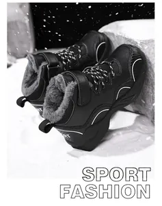 Close-up view of black children's winter sneakers with thick faux fur lining in a snowy scene