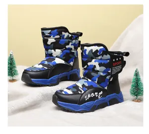 Blue camouflage kids snow boots with warm fleece lining on artificial snow background