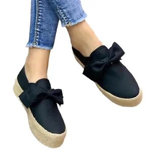 Women's black espadrille platform shoes with large decorative bow and jute sole