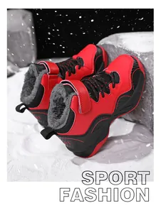 Close-up of red and black children's winter sports shoes with warm fur lining in snow