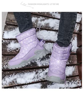 Stivali da neve viola per bambini con fiocchi di neve su una terrazza innevata