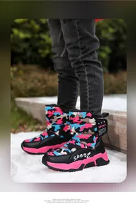 Full view of children wearing pink and blue camouflage winter snow boots outdoors