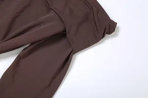 Gros plan du design croisé sur une robe fourreau marron à manches longues élégante.