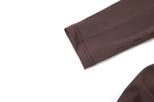 Détail du poignet de la manche d'une robe marron à manches longues avec couture
