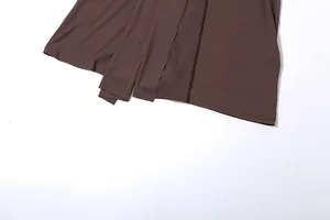 Gros plan de l'ourlet d'une robe marron montrant les coutures et la texture du tissu
