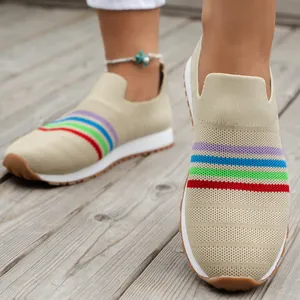 Close-up of breathable fly-knit slip-on sneakers with vibrant multi-color stripes.
