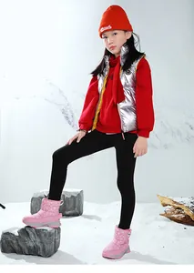 Détail des bottes de neige roses pour enfants avec motifs de flocons blancs portées par une fille.