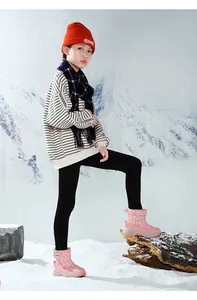 Fille asiatique portant des bottes de neige roses chaudes avec motif de flocons de neige