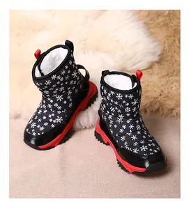 Vue détaillée des bottes de neige noires pour enfants avec semelles rouges et doublure en fourrure