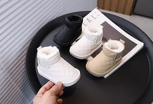 Gros plan de bottes de neige pour enfants doublées de polaire en blanc, noir et beige.