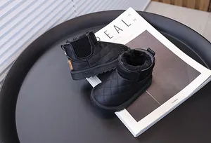 Gros plan détaillé des bottes d'hiver matelassées noires pour bébé avec doublure chaude.