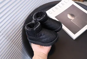 Détail des bottes de neige matelassées noires pour enfants avec doublure en fourrure.