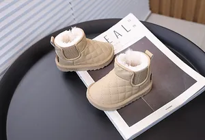 Gros plan de bottes de neige beige pour enfants avec surpiqûres et doublure en fourrure.