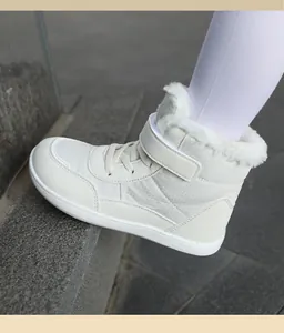 Side view detail of white fur-lined high-top children's snow boots with Velcro strap