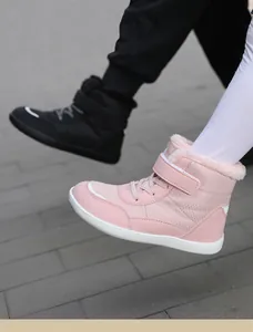 Close-up detail of warm pink children's snow boots featuring soft fleece lining and Velcro strap