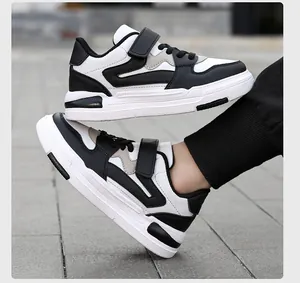 Vista lateral de zapatillas infantiles en blanco y negro con cierre de velcro