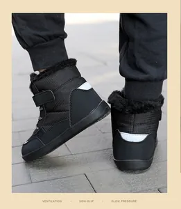 Close-up detail of children's black fur-lined winter snow boots with reflective heel patch