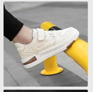 Detalle de zapatillas infantiles de cuero crema con un práctico cierre de velcro lateral