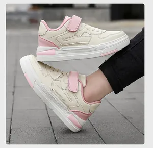 Zapatillas infantiles crema y rosa con tiras de velcro y acabado de cuero sintético.