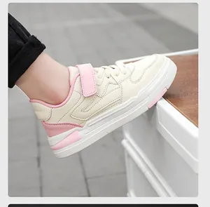Vista detallada de zapatilla de cuero beige y rosa para niños con práctico cierre de velcro